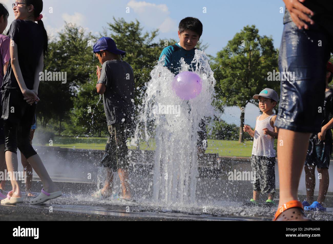 Kids splash fountain water at a water park in Isesaki, Gunma Prefecture