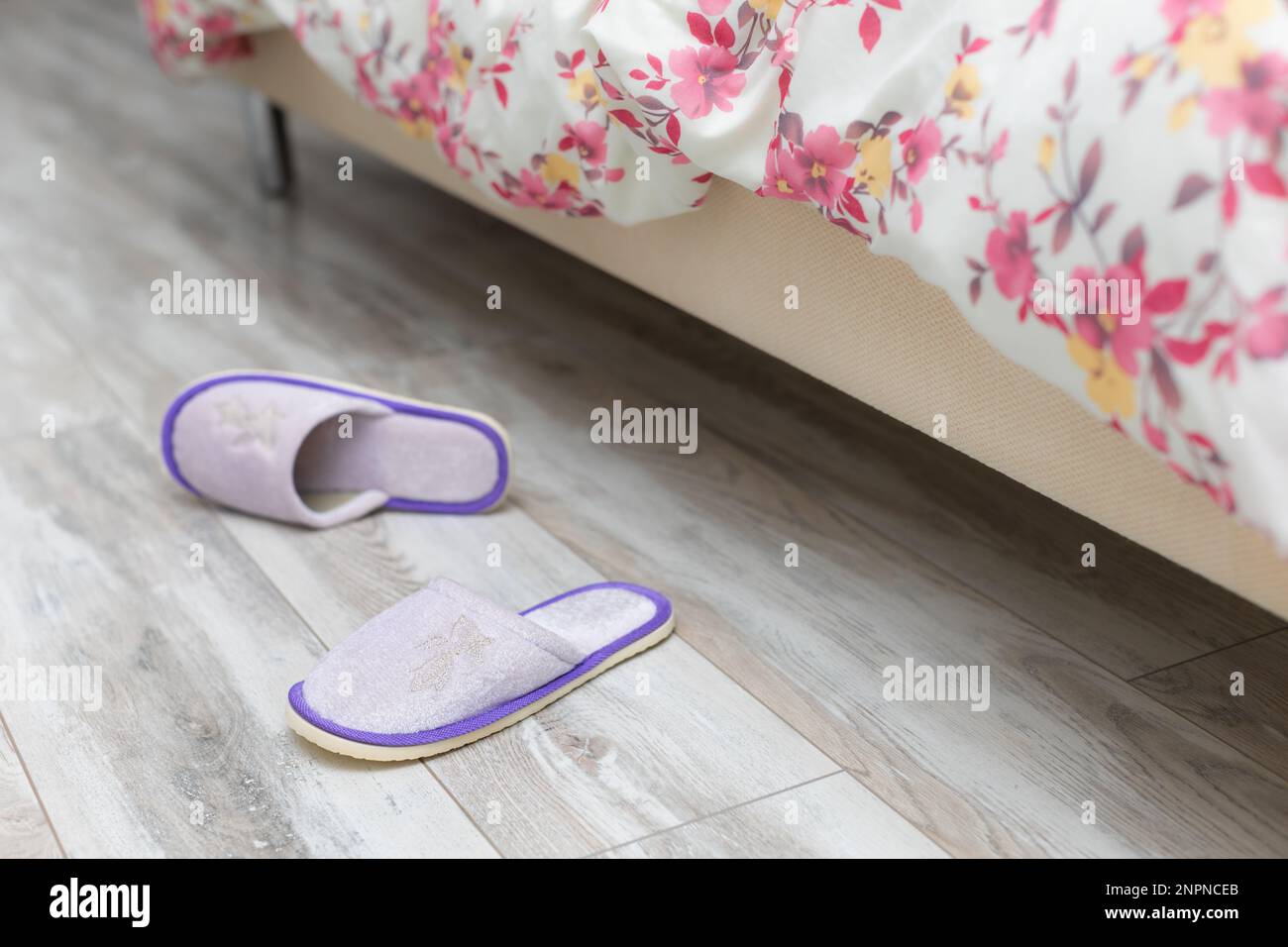 slippers near the bed on which the person sleeps. slippers next to the bed. slippers in the bedroom. morning at home Stock Photo