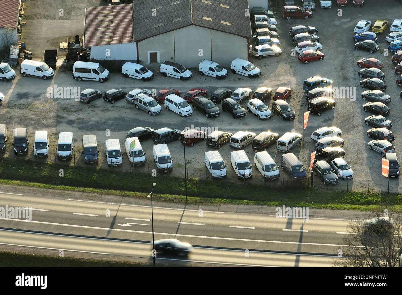 Aerial view of many colorful cars parked on dealer parking lot for sale