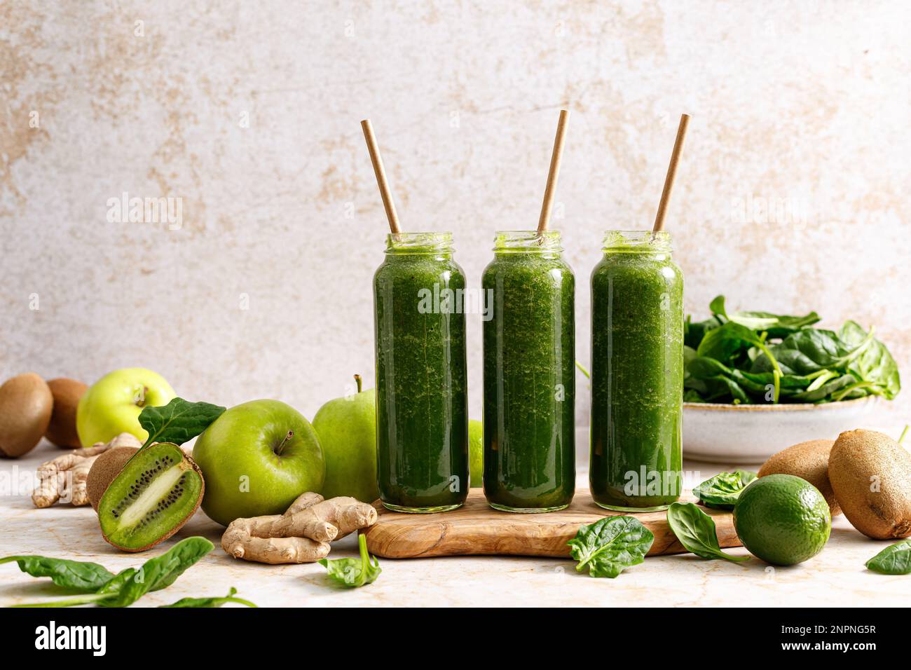 Smoothie. Healthy fresh raw detox spinach smoothie with green apple, kiwi and ginger in a bottles on a table. Healthy diet vegan food full of antioxid Stock Photo