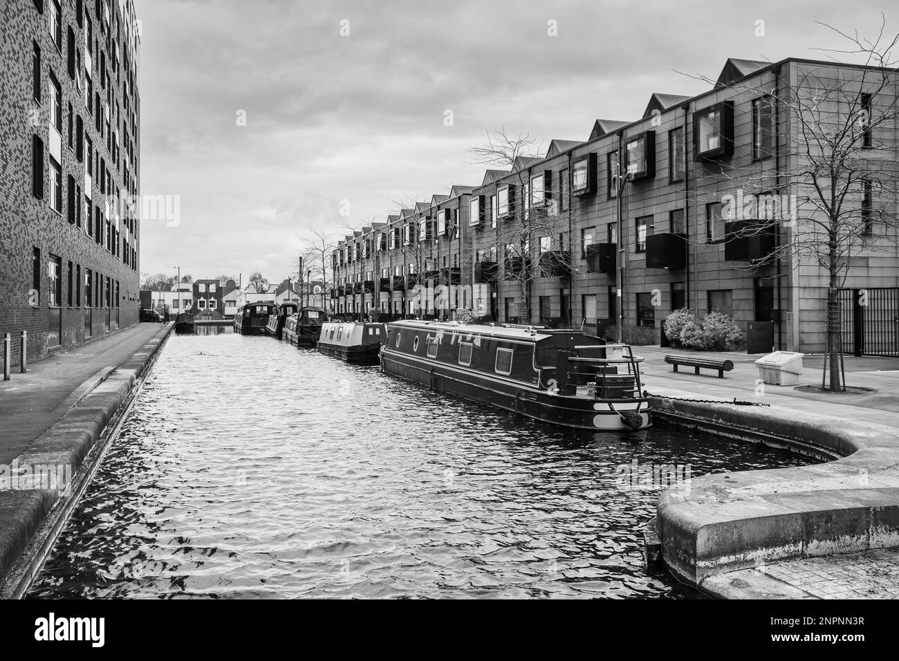 A line of narrow boats seen moored between Cotton Field Wharf and Keepers Quay in the New Islington marina part of the Rochdale canal Manchester pictu Stock Photo