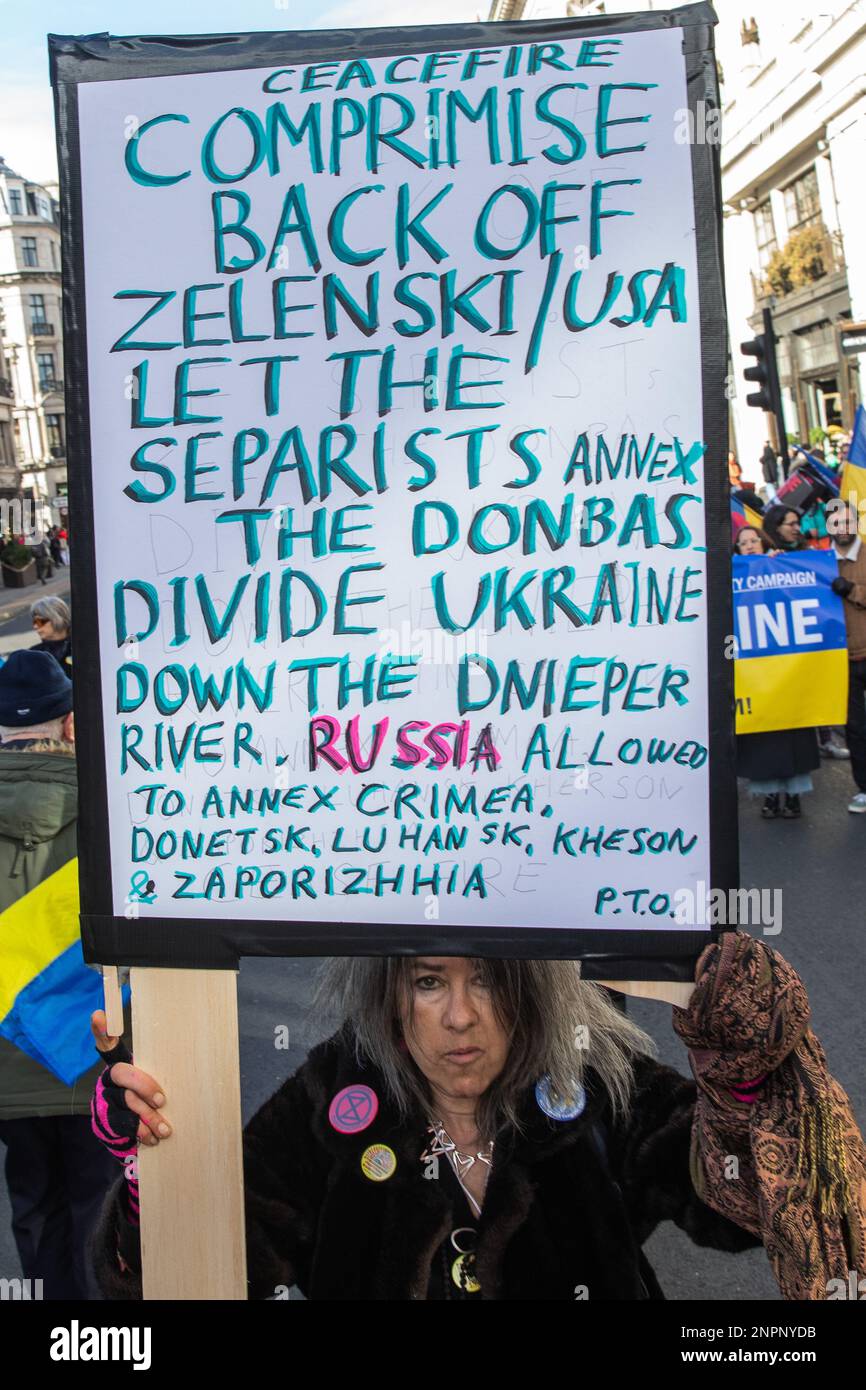 London, UK. 25th February, 2023. A woman holds a sign in front of supporters of Ukraine Solidarity Campaign staging a counter-protest to a march by Stop The War Coalition (StWC) and the Campaign for Nuclear Disarmament (CND) calling for a ceasefire and negotiated settlement in Ukraine. The counter-protest was joined by human rights and LGBT+ activist Peter Tatchell. Credit: Mark Kerrison/Alamy Live News Stock Photo