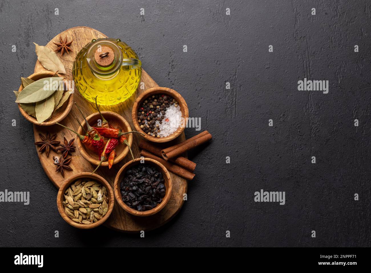 Various dried spices and olive oil on wooden board Stock Photo