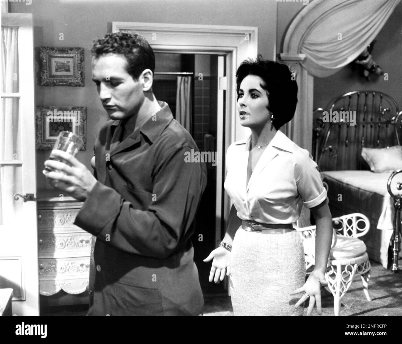 1958 : The movie actress ELIZABETH TAYLOR ( London , England 1932 ) and PAUL NEWMAN  in THE CAT ON A HOT TIN ROOF ( La gatta sul tetto che scotta ) by Richard Brooks , from a play by Tennessee Williams - CINEMA - portrait - ritratto  - innamorati - amanti - lovers - marito e moglie - husband and wife - pigiama - pajama - drink   - spalla - spalle - shoulders  - Liz  - collana - necklace - orecchino - orecchini - eardrops - jewels - gioiello - gioielli - bracelet - braccialetto - bracciale -  belt - cintura - abito vestito bianco - white dress - bed - letto - GAY - homosexuality - omosessualità Stock Photo