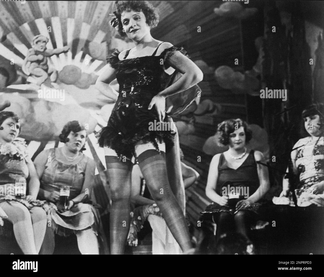 1930 :The german movie actress  MARLENE DIETRICH is Lola - Lola in THE BLUE ANGEL ( Der Blaue Engel - L' Angelo azzurro ) by JOSEF von STERNBERG  - FILM - CINEMA - cabaret - tabarin - leggy pose - gambe - legs - guepiére - calze di seta nera - giarrettiera - giarrettiere - black silk stockings - ballerina - dancer - singer - cantante  ----  Archivio GBB Stock Photo