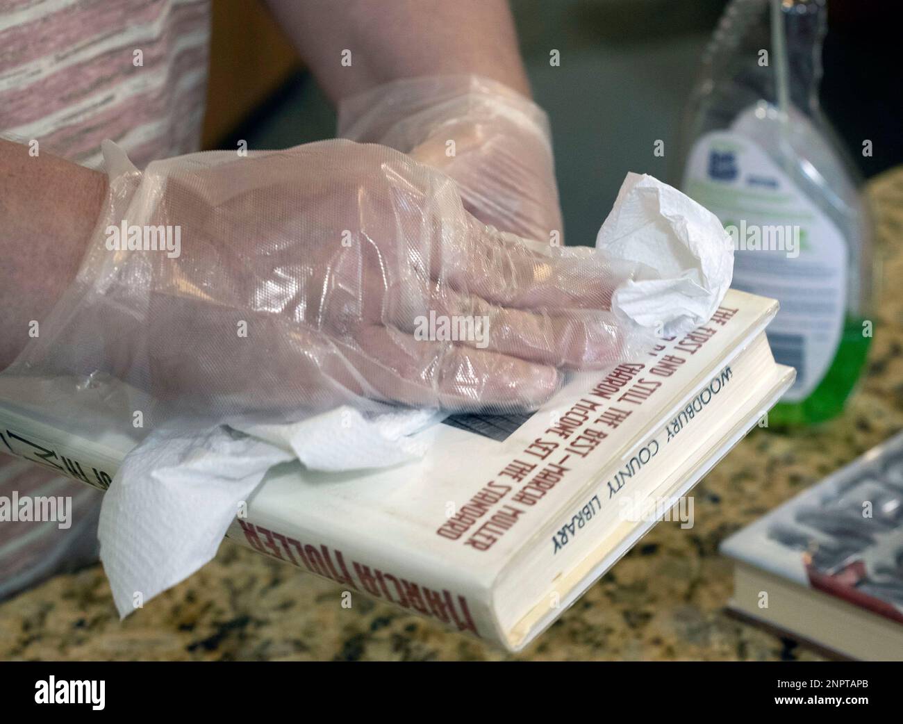 Carrie Stamm, a librarian at the Woodbury County Library, wipes a book