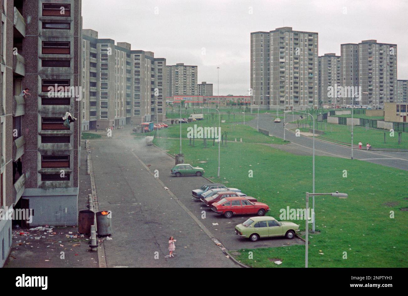 Shangan Road, flats, tower blocks, cars, man throwing garbage off his balcony, garbage is burnt in a barrel, Ballymun, Dublin, Republic of Ireland, June 1986 Stock Photo