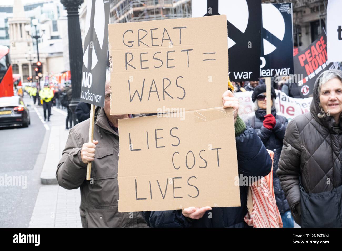 London, UK. 25th Feb, 2023. A protester holds a placard that reads 'Great reset = Wars', and 'Lies cost lives' during a demonstration march. Following the first anniversary of Russia-Ukraine War, protest groups gathered in Central London and marched to Trafalgar Square, calling for peace in Ukraine and Iran. Credit: SOPA Images Limited/Alamy Live News Stock Photo