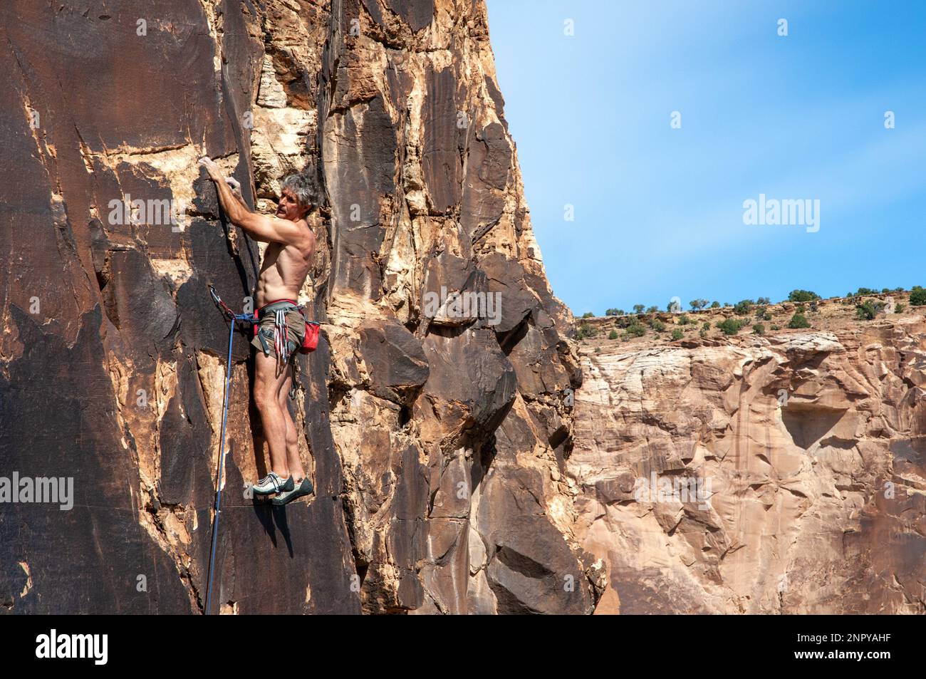 Adult male rock climbing in the central Utah desert. USA Stock Photo