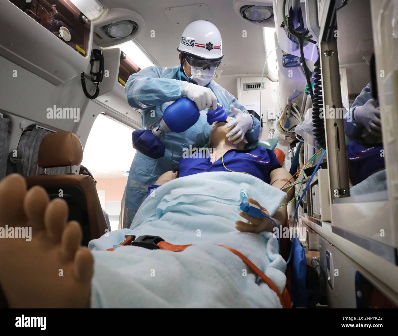 An emergency staff places a ventilator on patient doll's mouth during a  drill of patient transportation in Kitakyushu, Fukuoka Prefecture on June  10, 2020. Grave patients of Coronavirus infection and others need