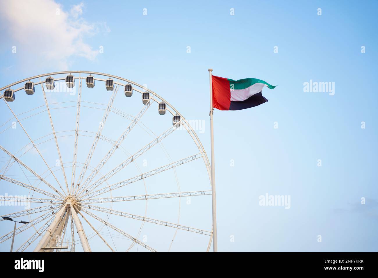 ABU DHABI, UAE  9jan2023. Marina Eye during a bright day, united arab emirates flag alone with wheel and blue sky, space for text on the left. Stock Photo