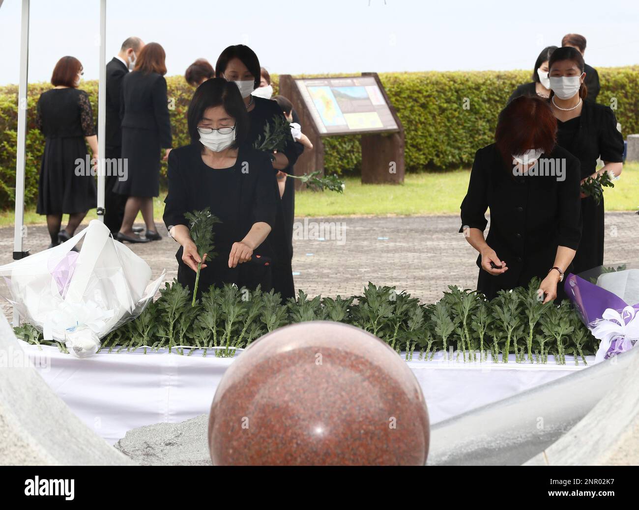 Bereaved family offer a flower at the victim cenotaph of the Mt. Unzen