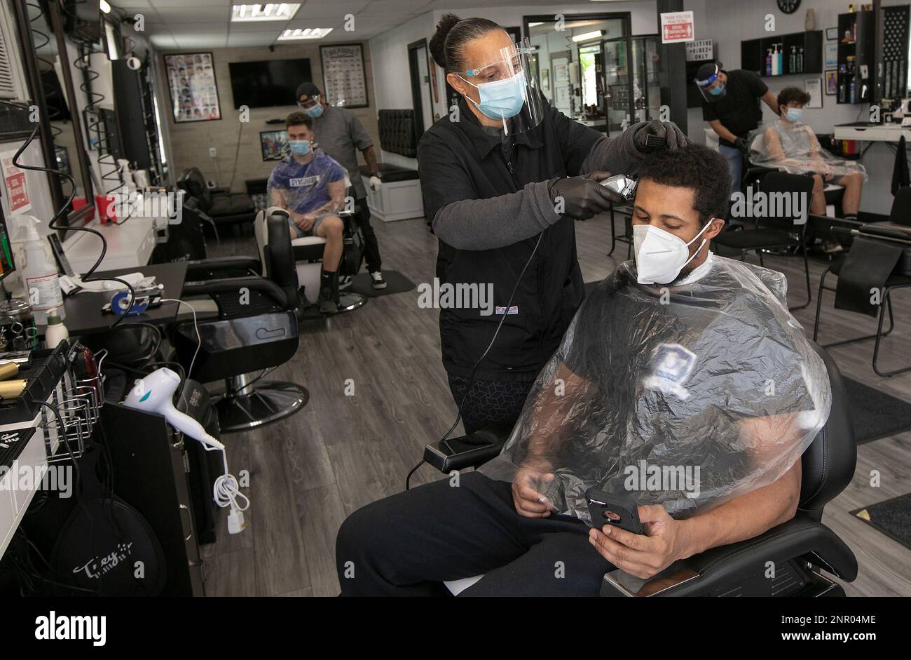 Barber Sherry Bronson gives a trim to customer Ron Davis, of Bristol