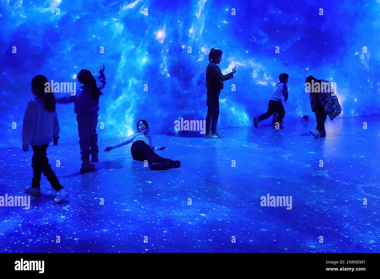 QINGDAO, CHINA - FEBRUARY 26, 2023 - Children and their parents enjoy the wonders of the universe at an indoor light film exhibition at Hisense Scienc Stock Photo