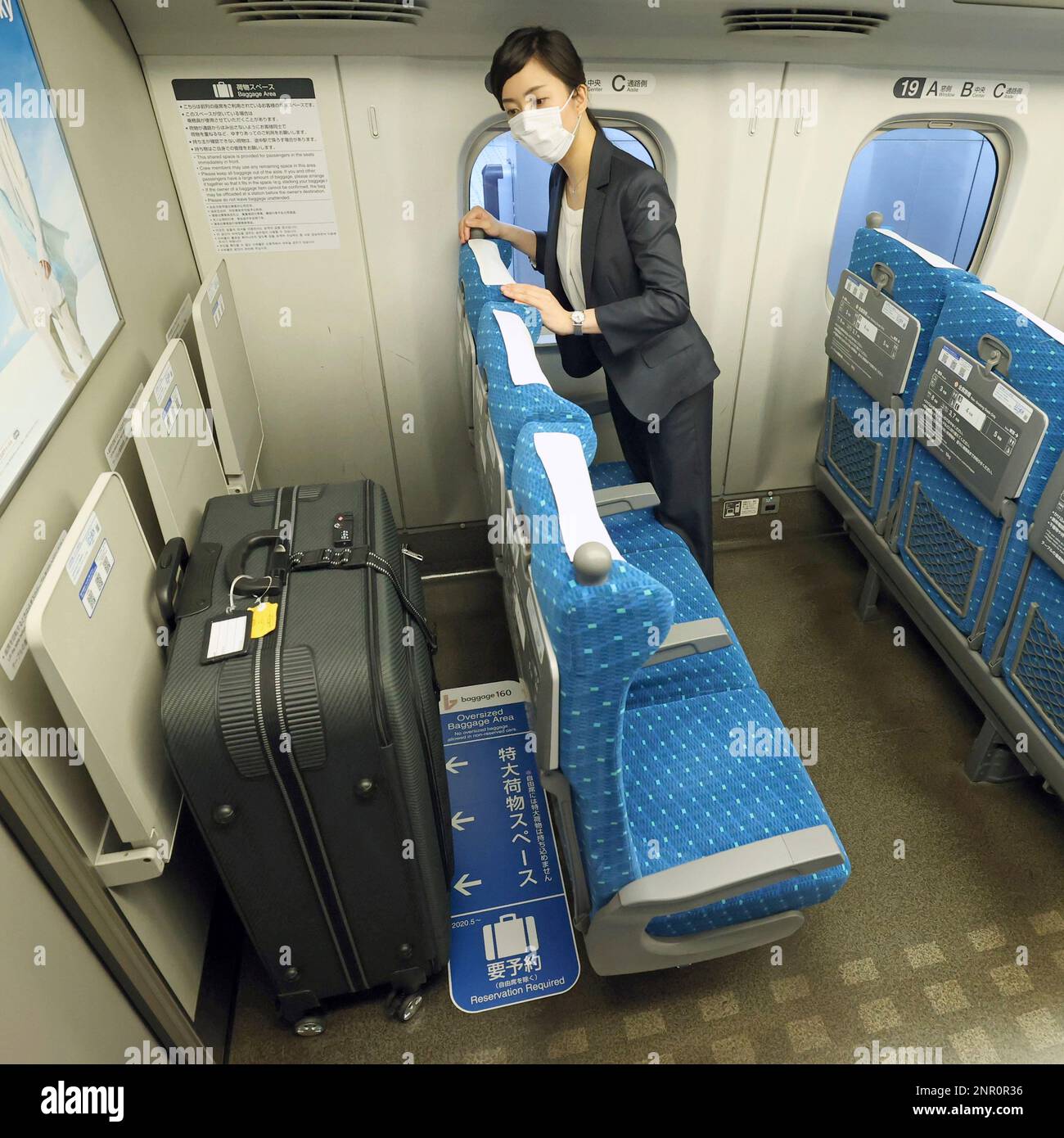 A woman demonstrates to bring her largesize baggage to check with