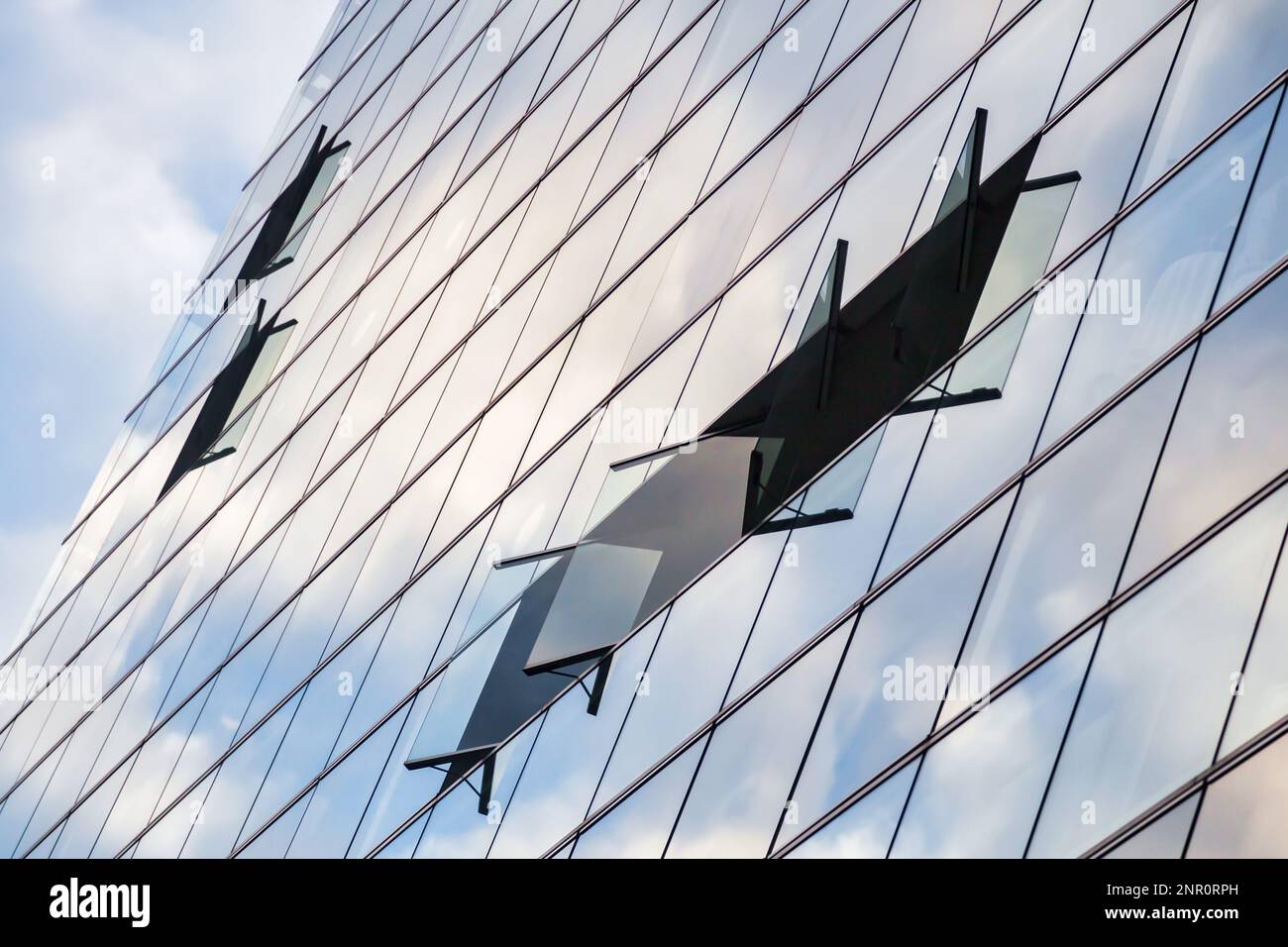 picture of a glass facade of an office building with reflecting sky in ...