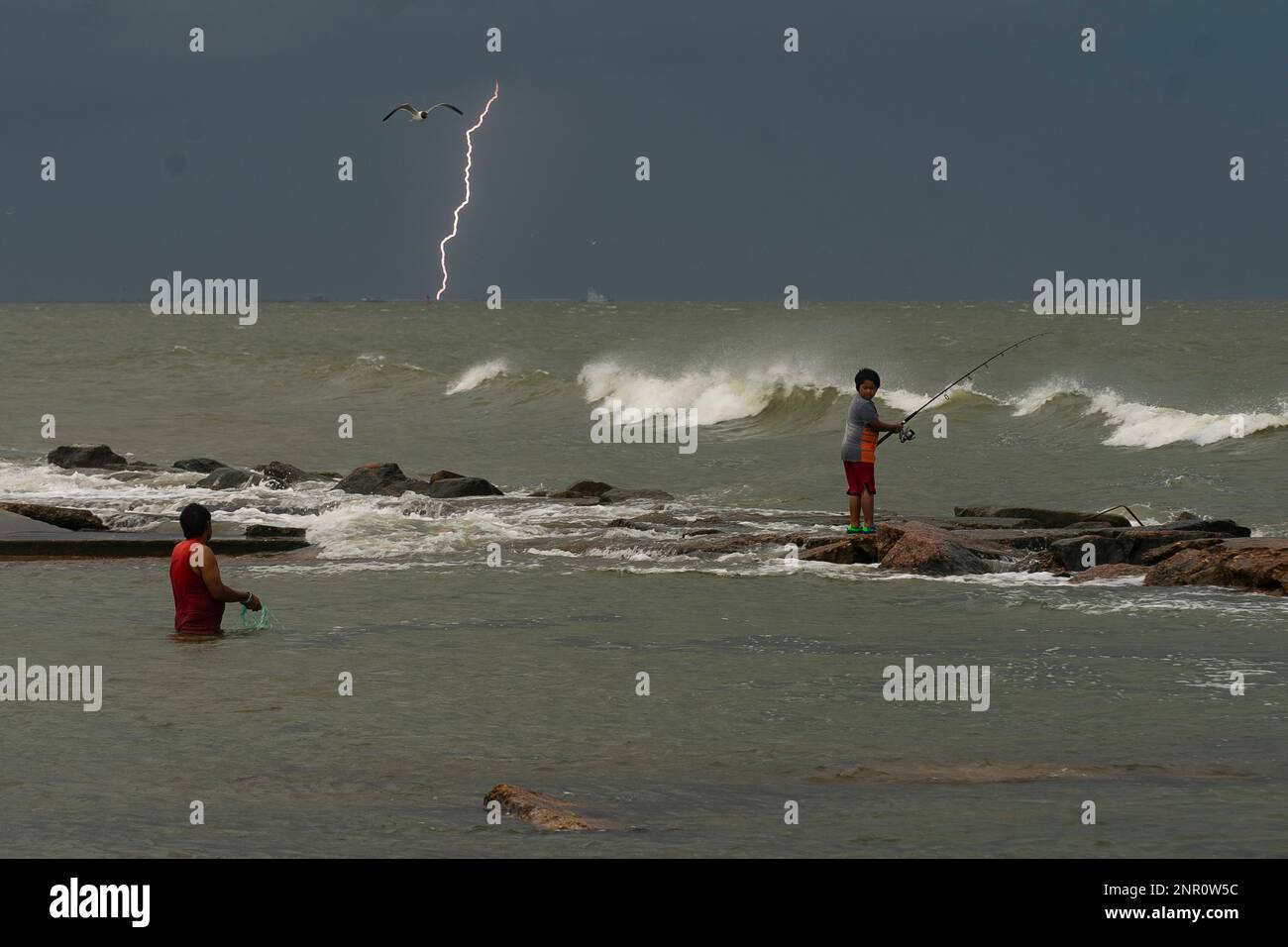 https://c8.alamy.com/comp/2NR0W5C/lightning-strikes-in-the-distance-as-people-fish-near-east-beach-friday-may-15-2020-in-galveston-texas-mark-mulliganhouston-chronicle-via-ap-2NR0W5C.jpg