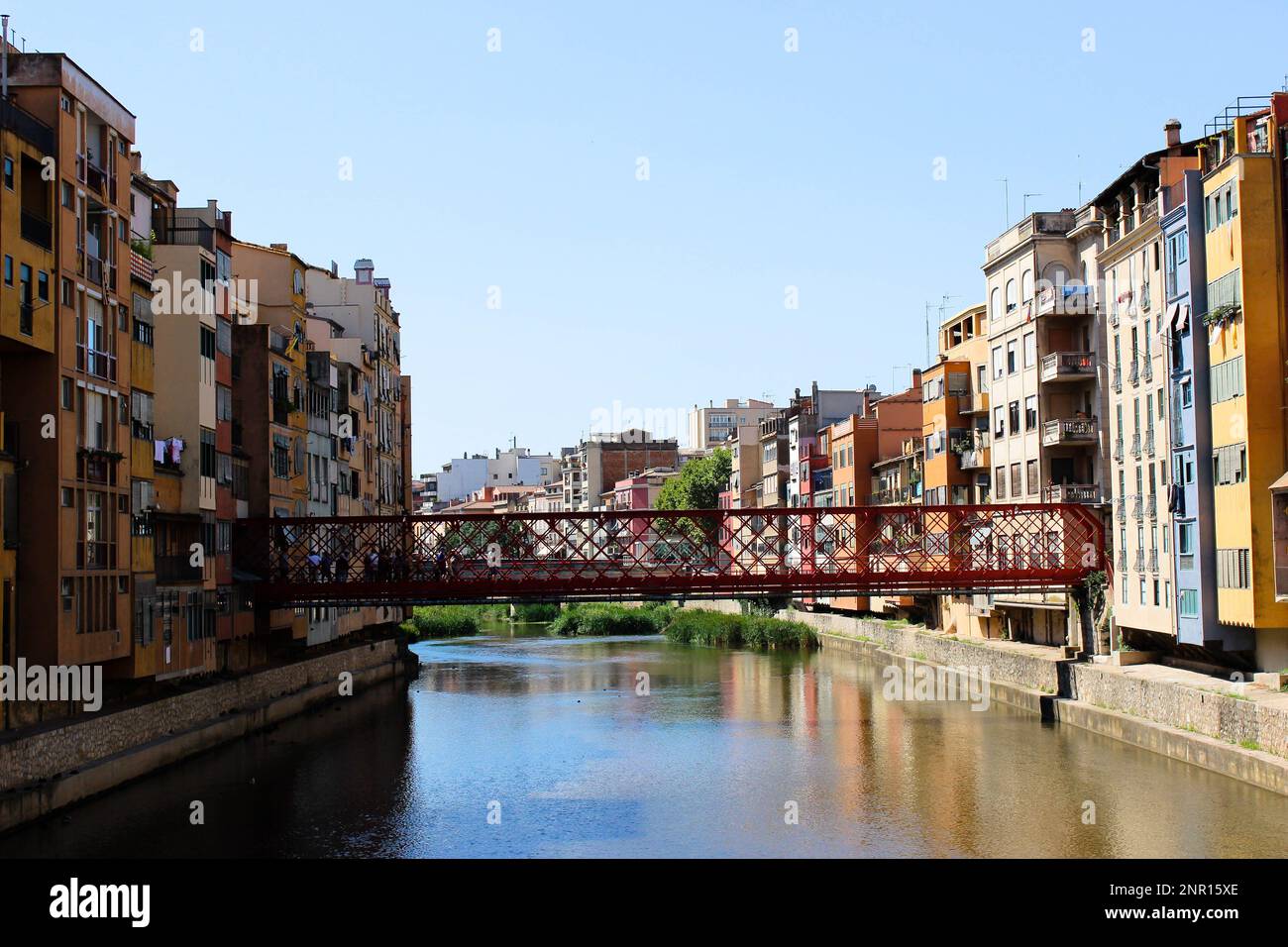 colorful 4- or 5-story buildings border a watercourse, which partially ...