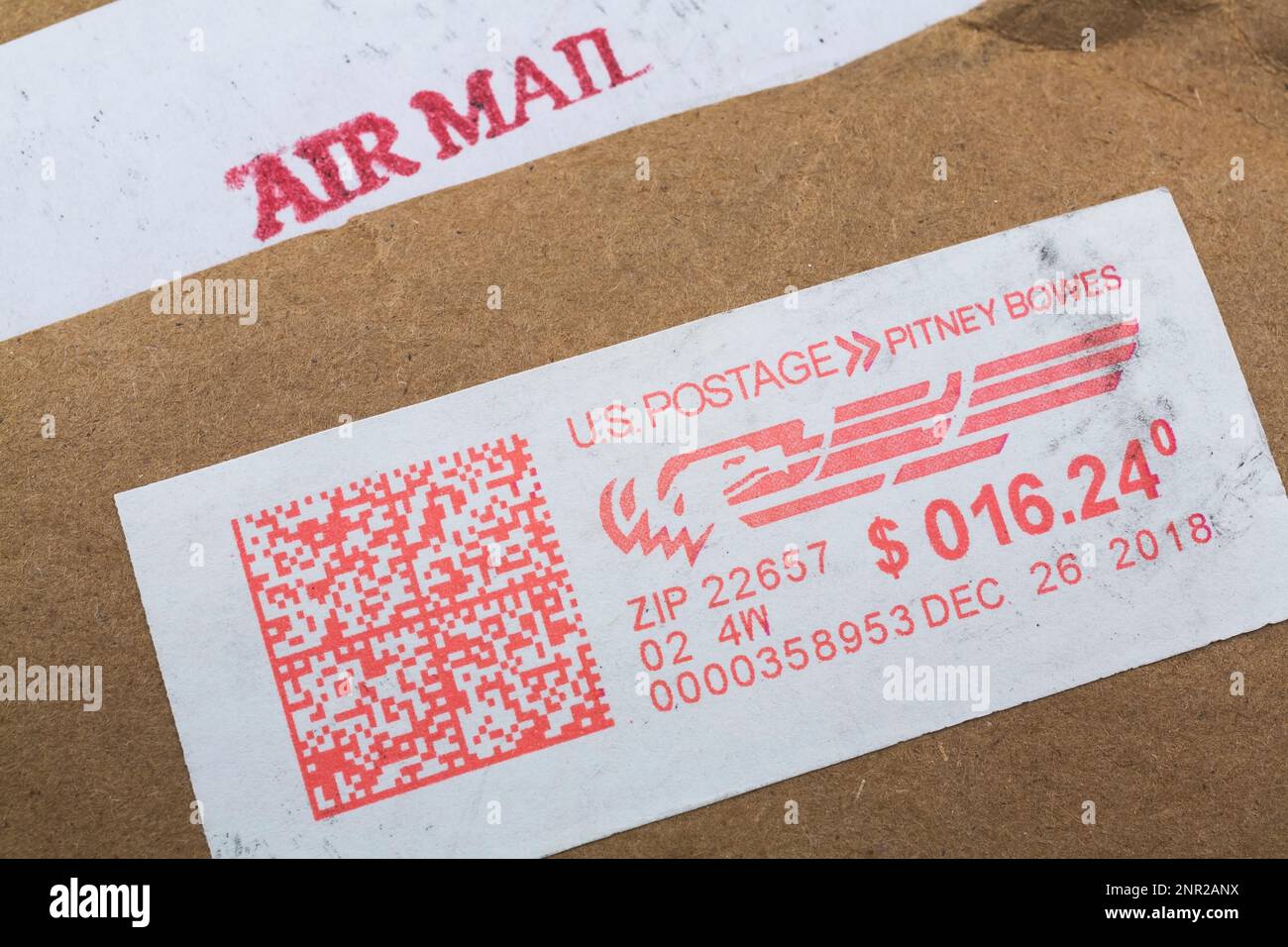 Red U.S. postage Pitney Bowes label on brown recycled paper envelope