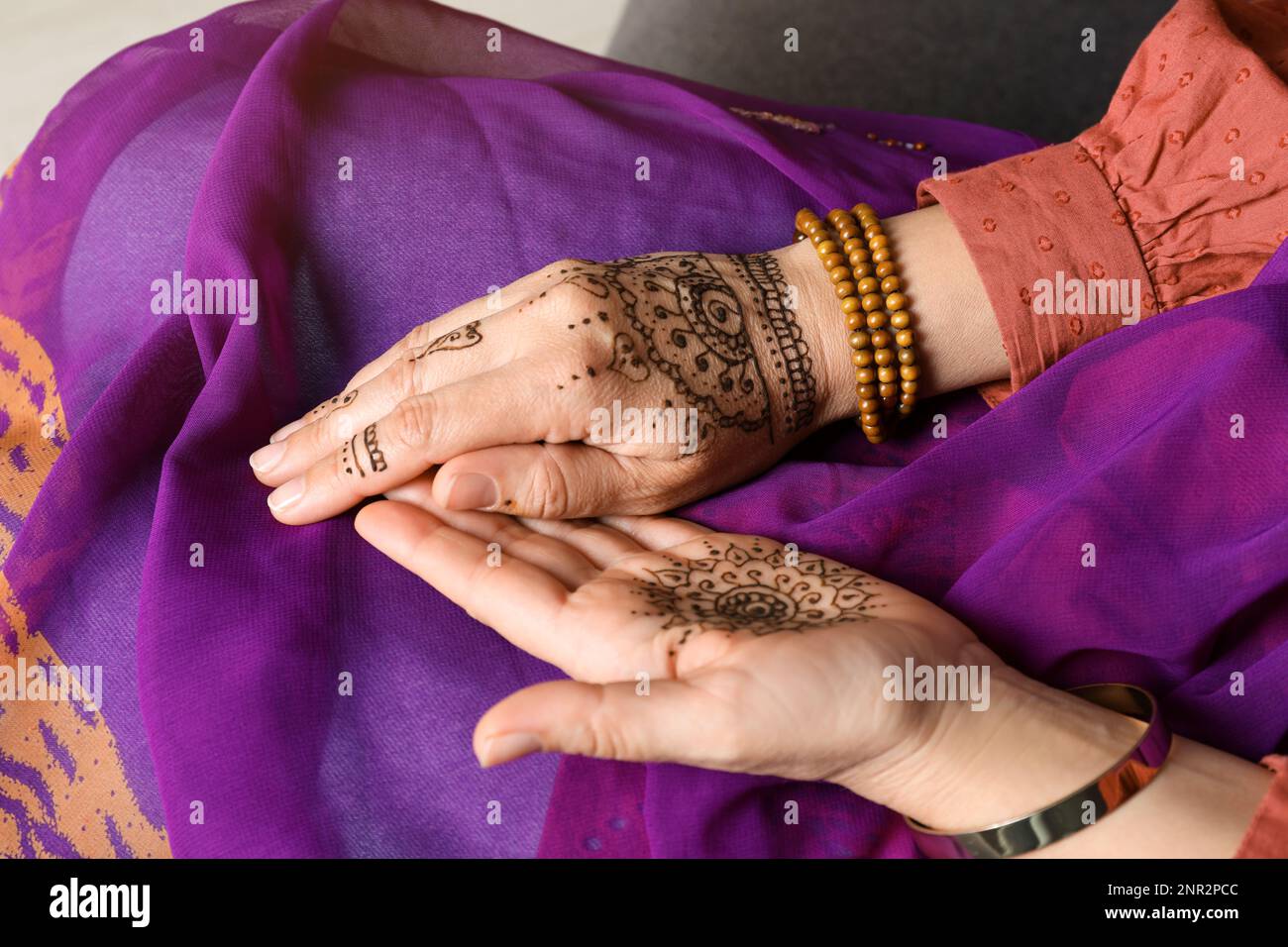 Woman with beautiful henna tattoos on hands, closeup. Traditional