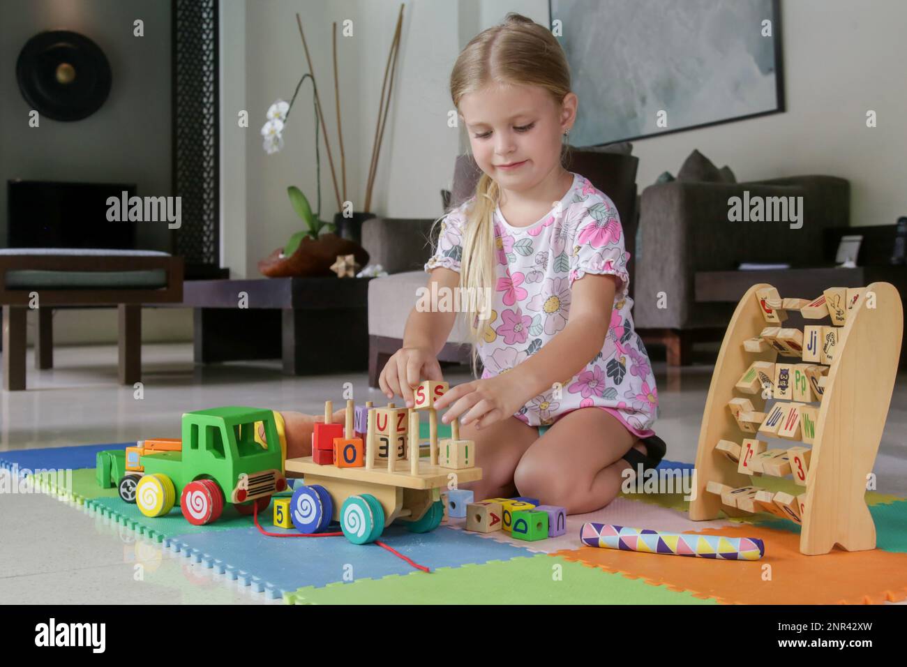 Adorable little girl playing with wooden toys at home Stock Photo - Alamy
