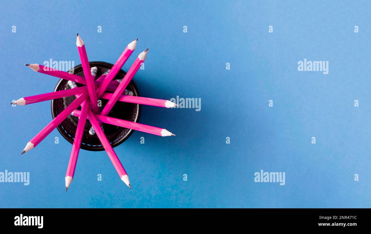 pink pencils holder against blue background Stock Photo Alamy