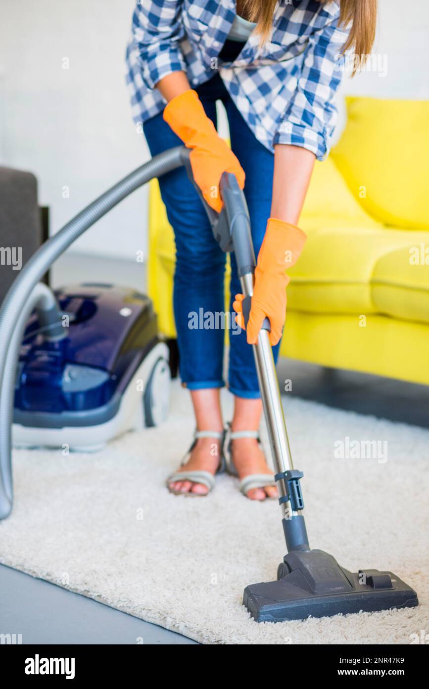 close up woman s hand cleaning carpet with vacuum cleaner Stock Photo
