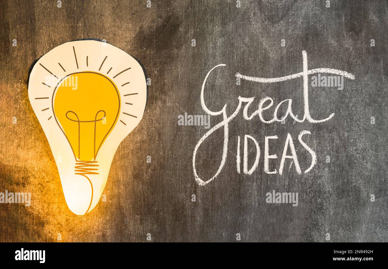 Paper cutout light bulb with great ideas text chalkboard Stock Photo