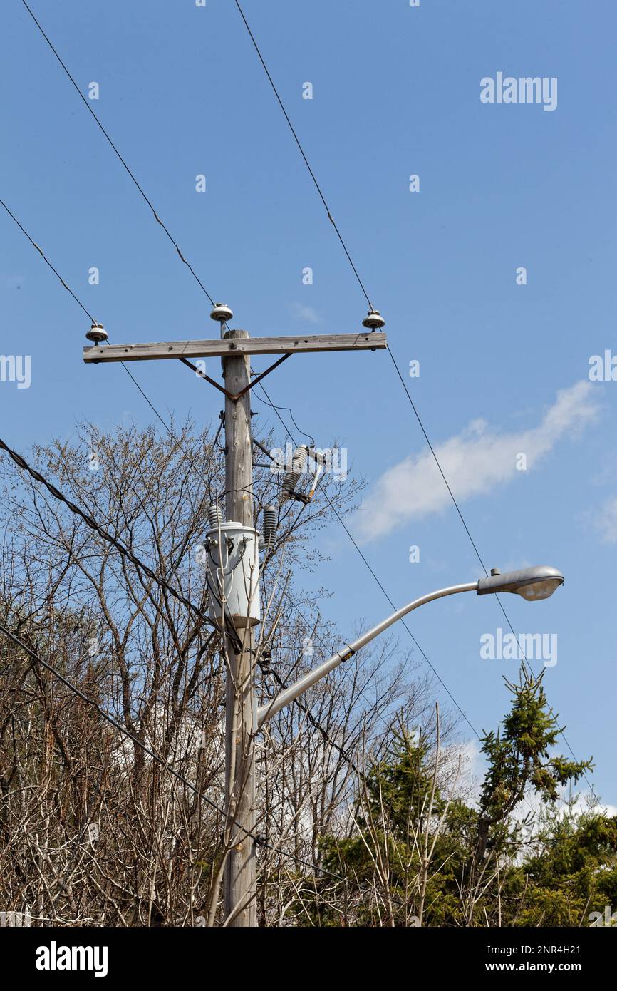 Utility pole with an electrical transformer and a street lamp. Quebec,Canada Stock Photo