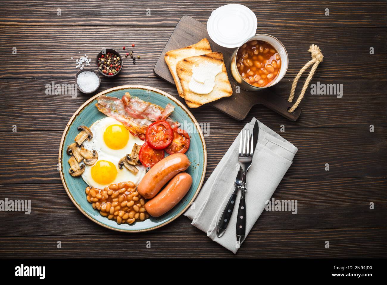 Full English breakfast with fried eggs, sausages, bacon, beans