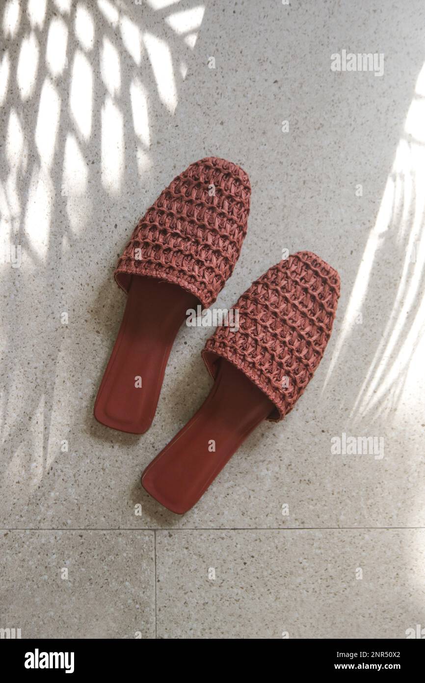 Handmade raffia mules. Sustainable ethically made pair of slippers. Responsibly sourced shoes with eco-friendly materials. Stock Photo