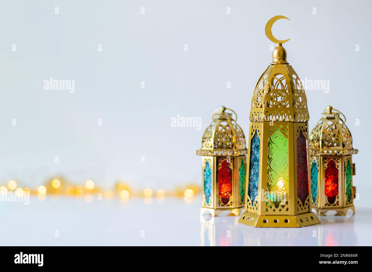 Golden lanterns put on white background with lights for the Muslim feast of the holy month of Ramadan Kareem. Stock Photo