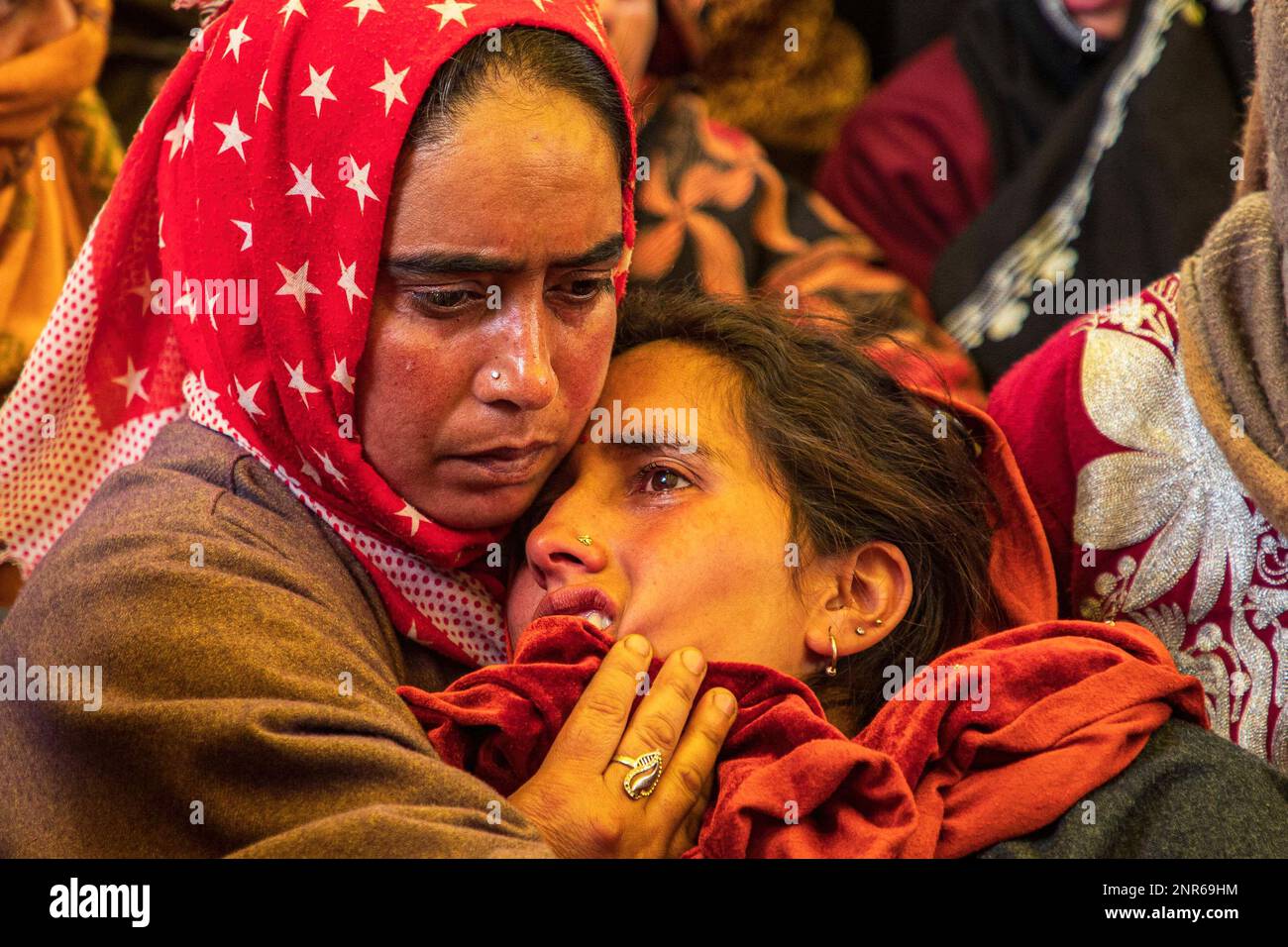 Srinagar, India. 25th Feb, 2023. A Kashmiri Muslim woman consoles a mourning wife of Sanjay Sharma a Kashmiri Hindu bank security guard who was shot dead by suspected militants in Pulwama South of Indian administered Kashmir. Police said suspected militants opened fire on Sanjay Sharma while he was on his way to a local market in Achan village Pulwama district. Credit: SOPA Images Limited/Alamy Live News Stock Photo