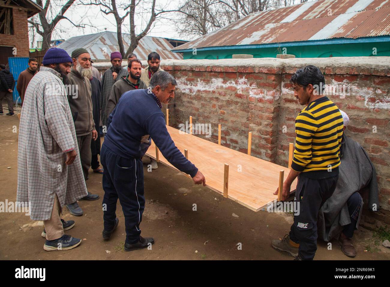 Srinagar, India. 25th Feb, 2023. Kashmiri Muslim neighbours making coffin for the dead body of Sanjay Sharma a Kashmiri Hindu bank security guard who was shot dead by suspected militants in Pulwama South of Indian administered Kashmir. Police said suspected militants opened fire on Sanjay Sharma while he was on his way to a local market in Achan village Pulwama district. Credit: SOPA Images Limited/Alamy Live News Stock Photo