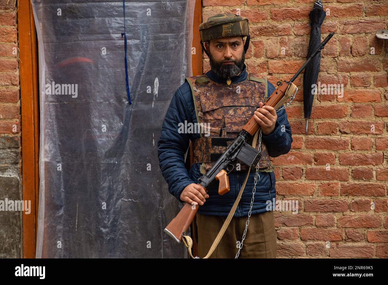 Srinagar, India. 25th Feb, 2023. Indian policeman stands on guard outside the house of Sanjay Sharma a Kashmiri Hindu bank security guard who was shot dead by suspected militants in Pulwama South of Indian administered Kashmir. Police said suspected militants opened fire on Sanjay Sharma while he was on his way to a local market in Achan village Pulwama district. Credit: SOPA Images Limited/Alamy Live News Stock Photo