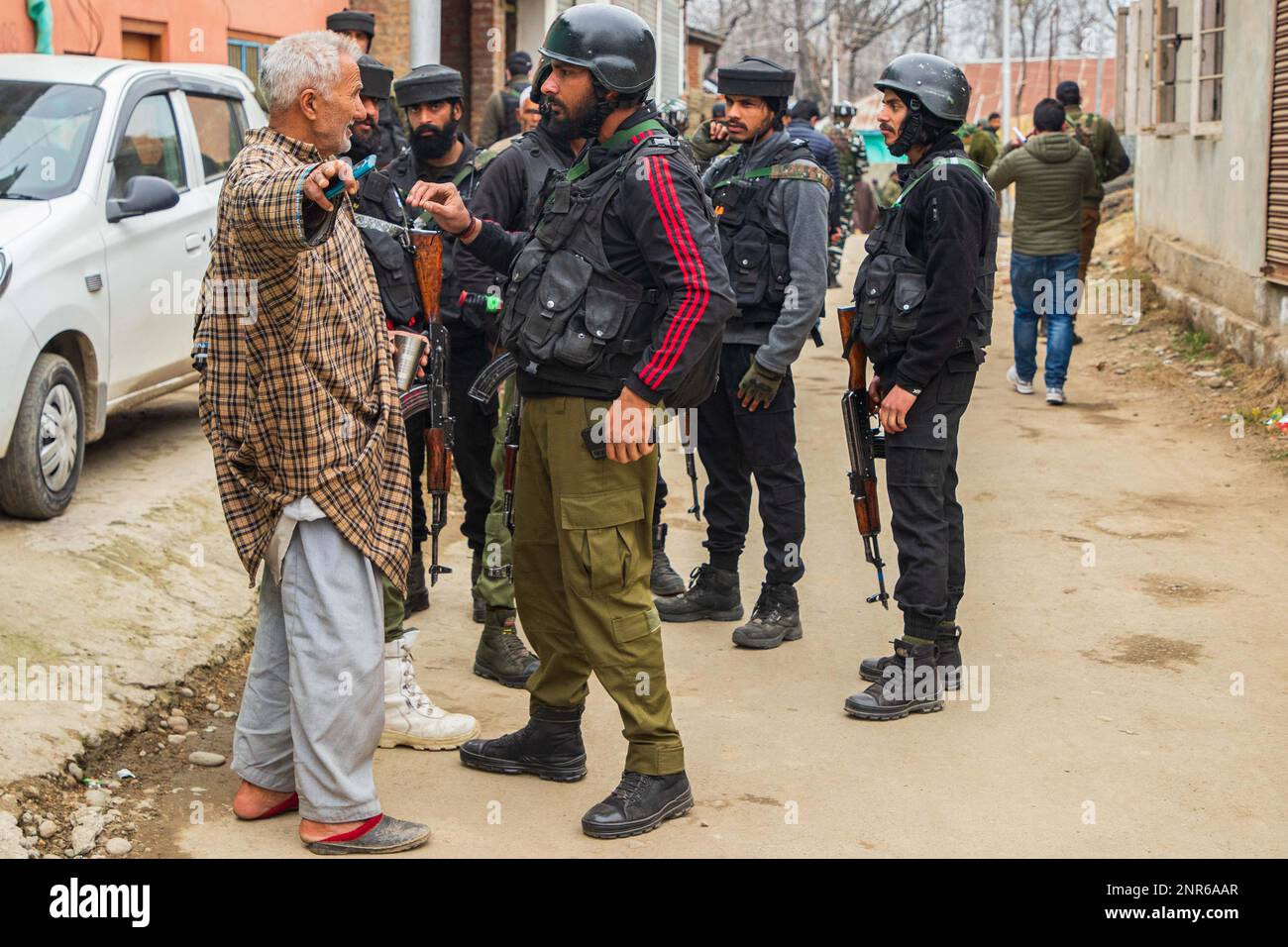 Srinagar, India. 25th Feb, 2023. Indian paramilitary troopers speak with a local resident at the attack site where Sanjay Sharma a Kashmiri Hindu bank security guard was shot dead by suspected militants in Pulwama South of Indian administered Kashmir. Police said suspected militants opened fire on Sanjay Sharma while he was on his way to a local market in Achan village Pulwama district. Credit: SOPA Images Limited/Alamy Live News Stock Photo