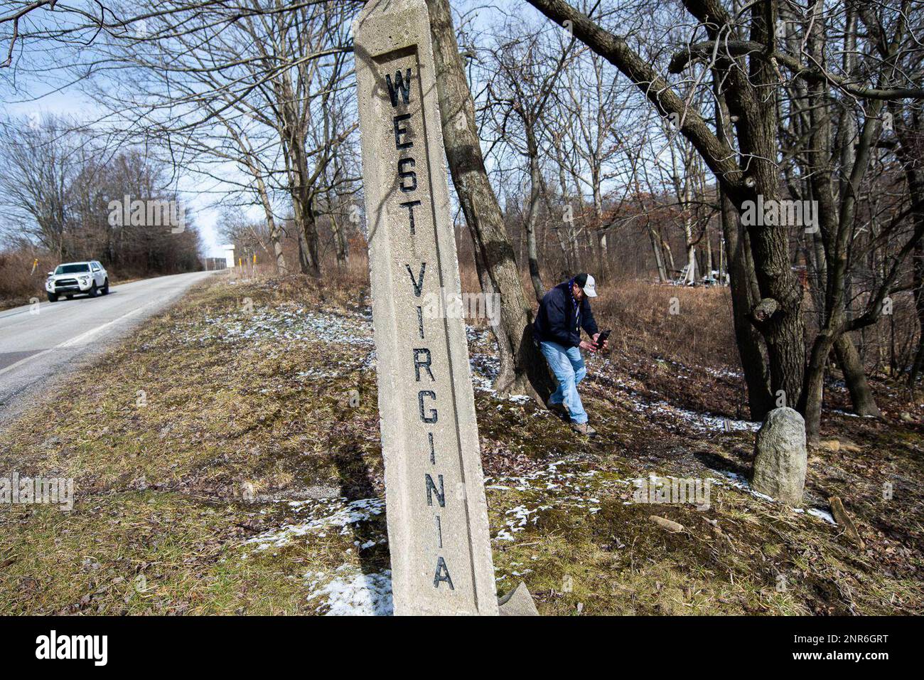 Pat Simon, a land surveyor from Bel Air, Md., and the chief of surveys for  Baltimore County, takes a photograph of a concrete state line marker  Saturday, Feb. 15, 2020 near the