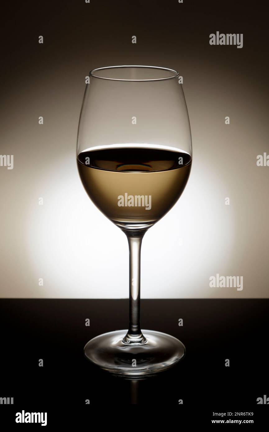 White wine in a backlit glass. Stock Photo