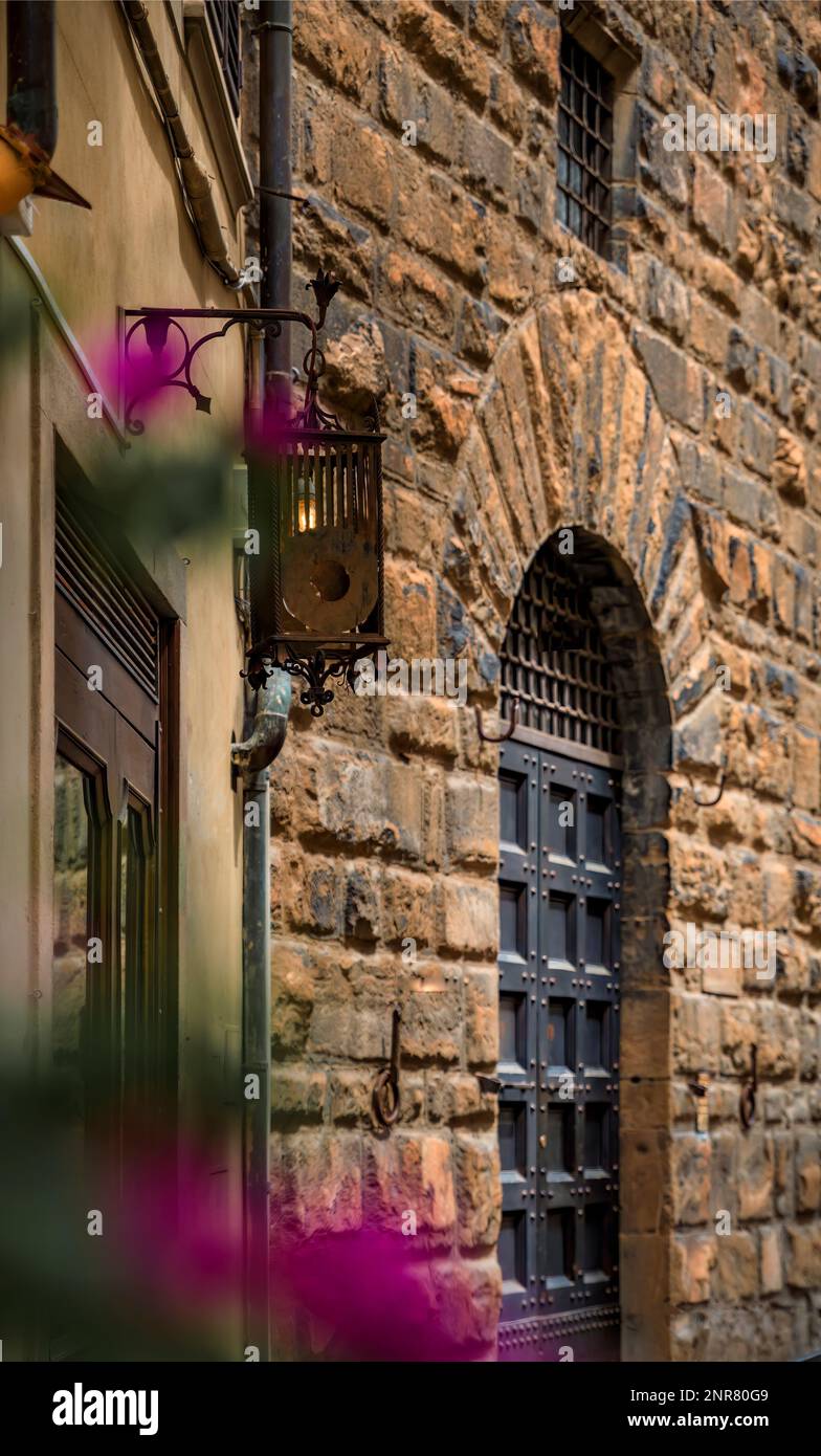 Medieval Renaissance gothic buildings and flowers on a narrow street in Oltrarno Santo Spirito, Centro Storico or Historic Centre of Florence, Italy Stock Photo