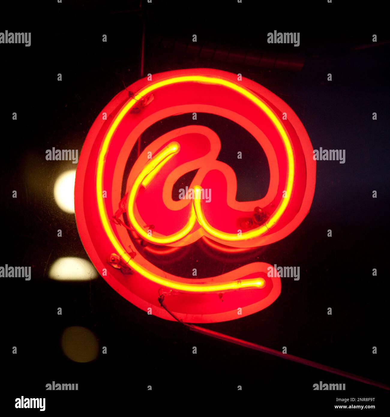 Outdoors red neon sign shaped into an 'at' symbol Stock Photo Alamy