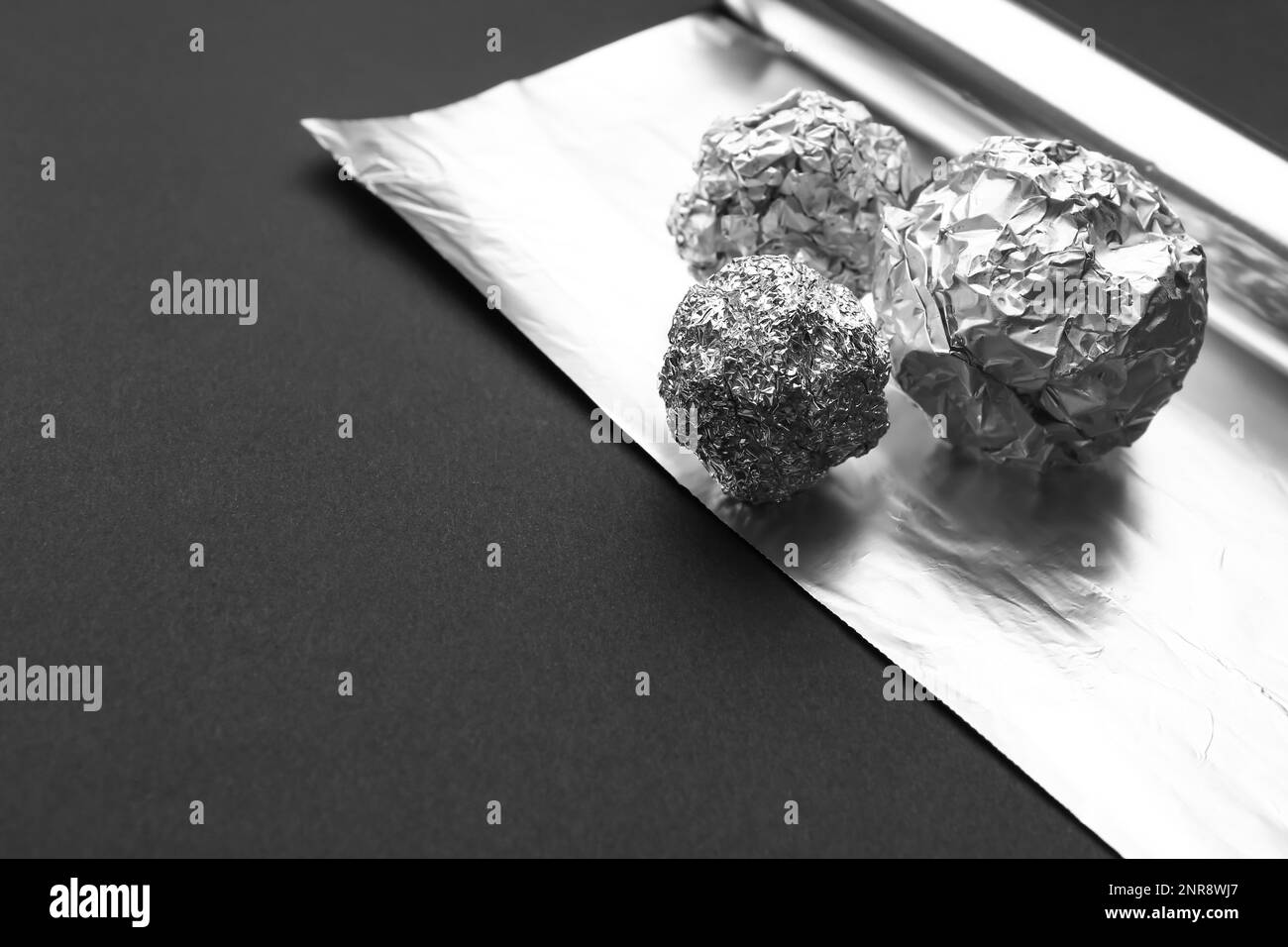 Crumpled balls of aluminium foil on dark background, closeup Stock Photo