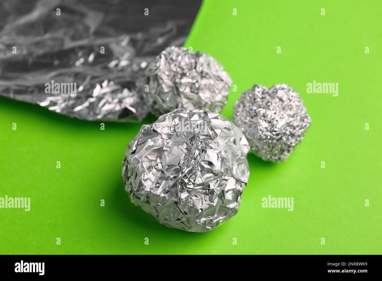 Crumpled balls of aluminium foil on green background, closeup Stock Photo Alamy
