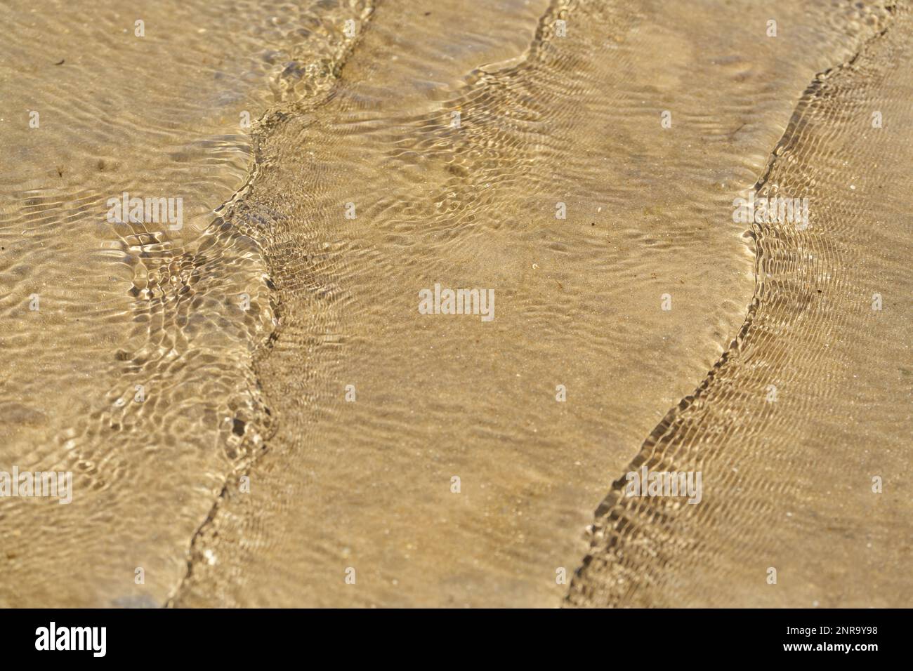 Looking down on gentle rippling waves in shallow clear water Stock Photo