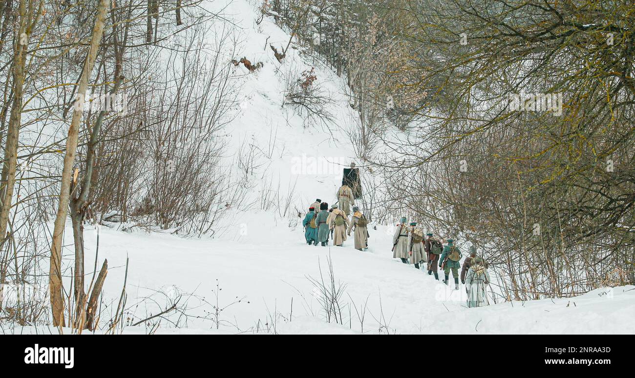 Men Dressed As White Guard Soldiers Of Imperial Russian Army In Russian Civil War s Marching Through Snowy Winter Forest. Historical Reenactment Stock Photo