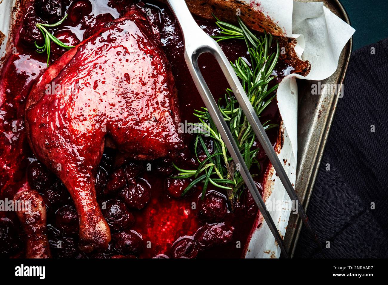 Baked duck legs with cherry red wine sauce with fresh rosemary in old