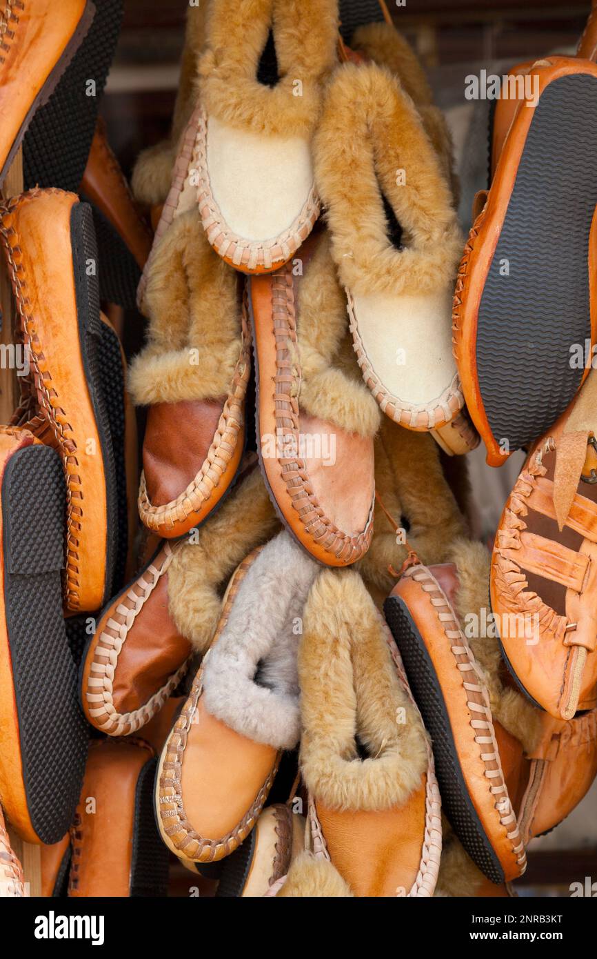 Stack of Opanci for sale on a market stall on Skopje, North Macedonia. Opanci are traditional peasant shoes worn in Southeastern Europe (specifically Stock Photo