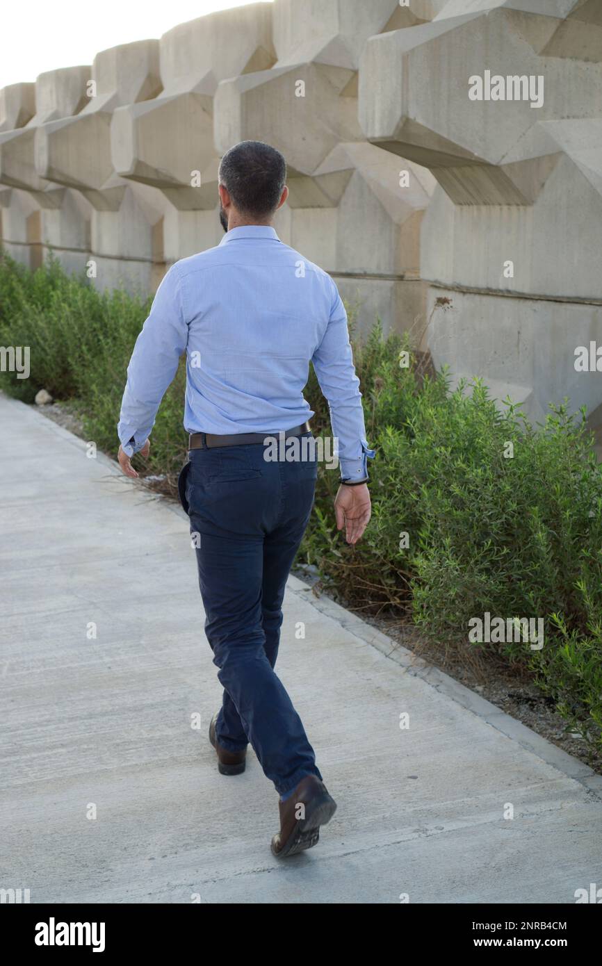 Rear view of man walking away Stock Photo