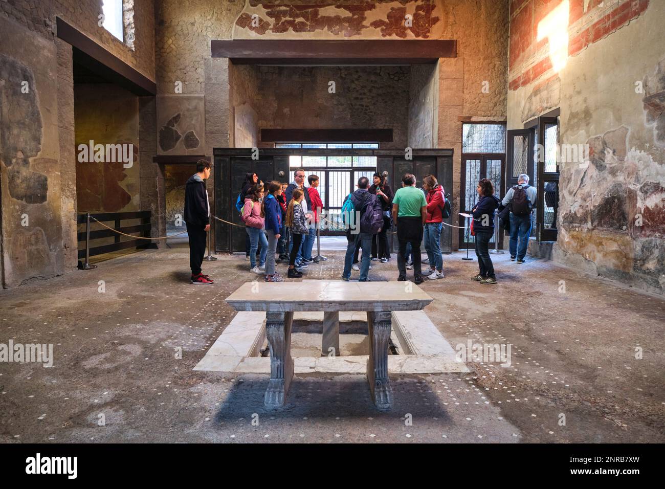 Tourists, visitors inspecting the big doors, still on metal runners. At the House of the Wooden Partition. At the Roman ruin archeological town, city Stock Photo