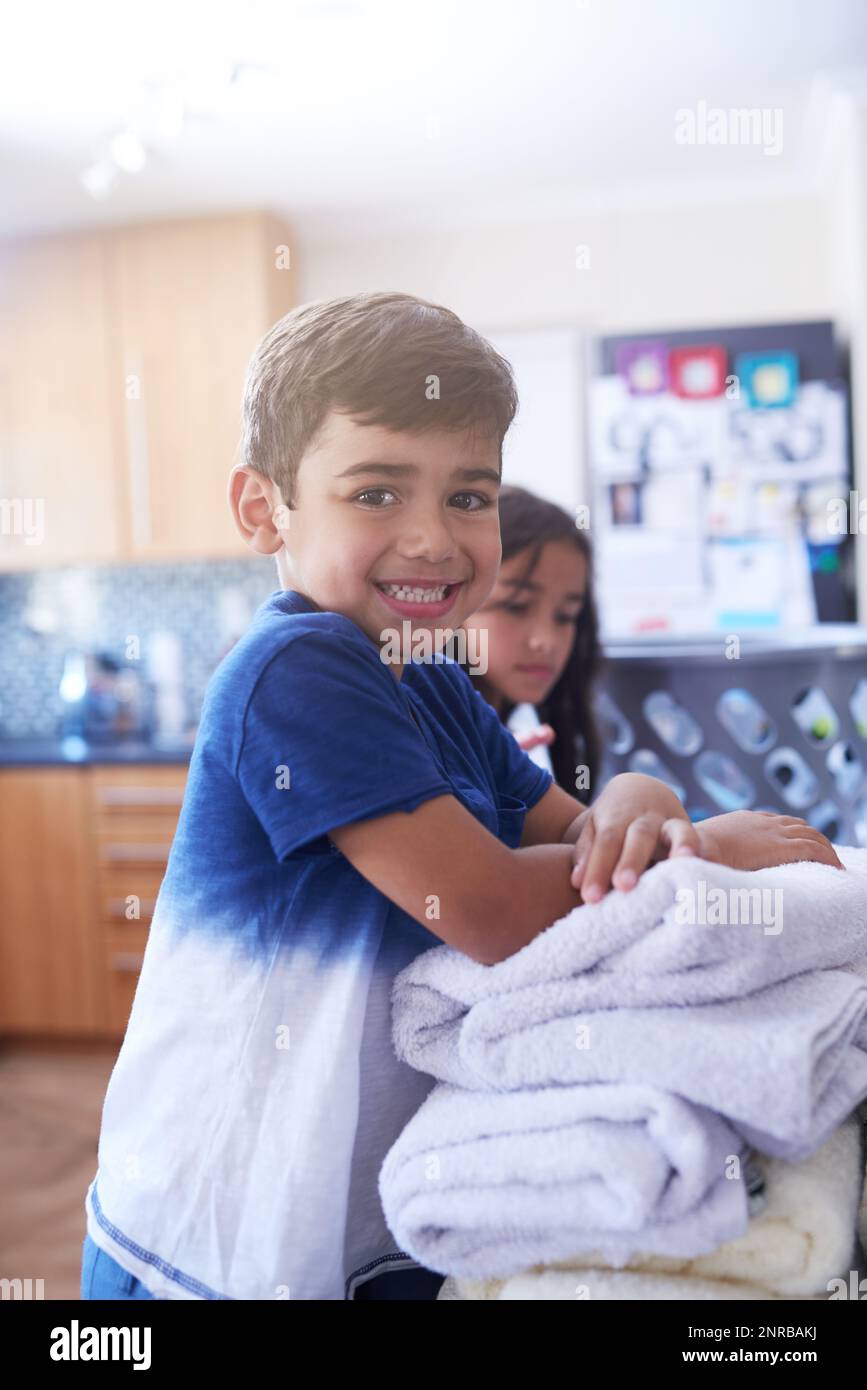 Laundry goes quicker when we do it together. Portrait of a little boy