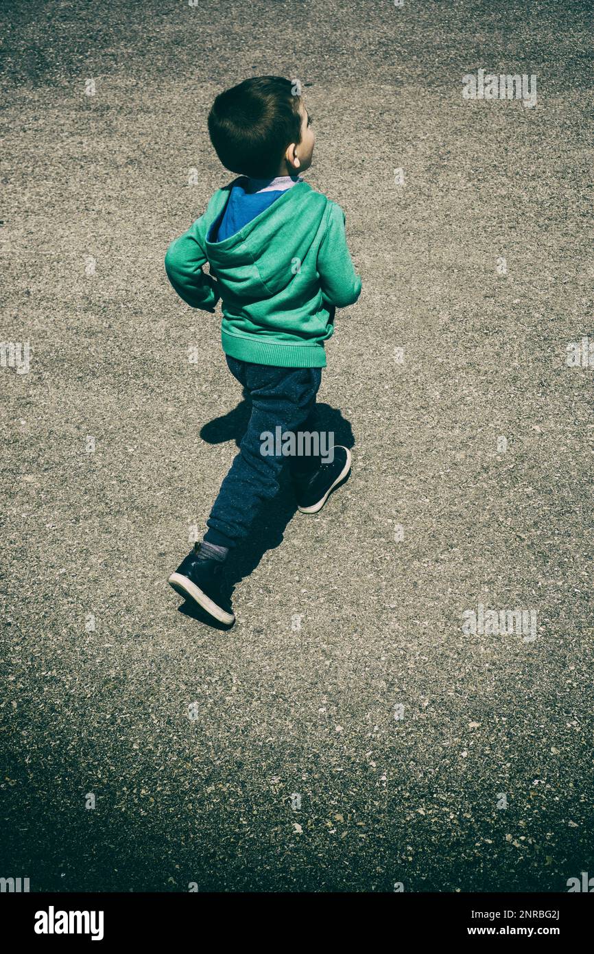 Boy running away on the street Stock Photo